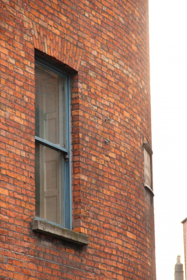 18th-century bowed red brick facade of Number 2 with Victorian sash window